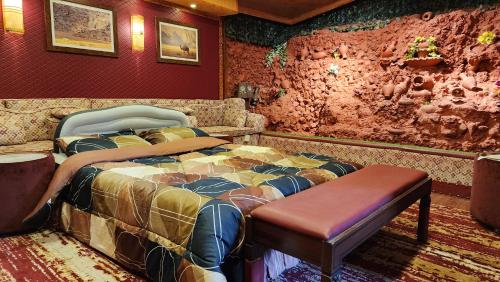 1 dormitorio con cama y banco. en Waterfall Hut - Live by a waterfall كوخ الشلال - عش وسط شلال, en Amán