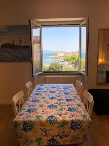 a dining room with a table and a large window at La Finestra sul Mare in Gaeta