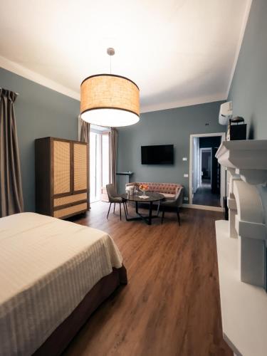 a bedroom with a bed and a dining room at Caffè delle Rose Les Chambres in Verbania