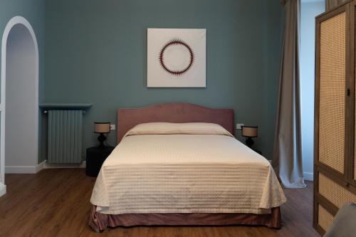 a bedroom with a bed and a painting on the wall at Caffè delle Rose Les Chambres in Verbania