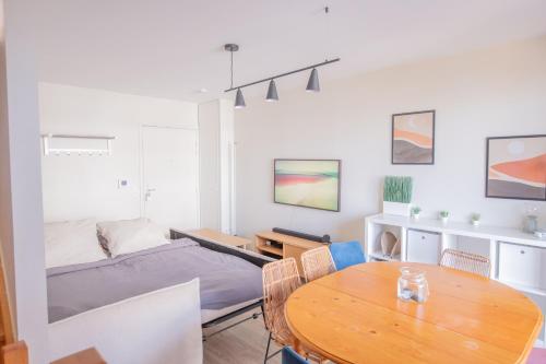 Sala de estar con cama y mesa en MACHOUART le duplex -Parking gratuit Équipée Commodités-, en Aubervilliers