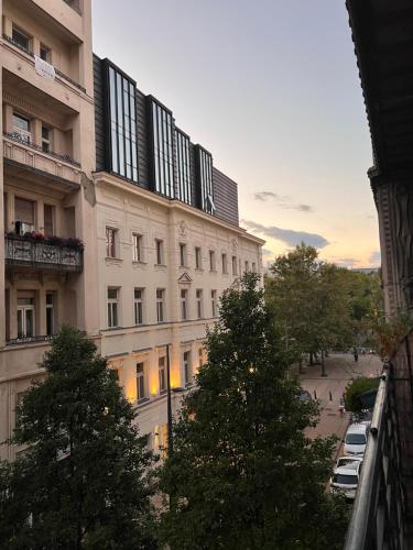 un grand bâtiment blanc avec des arbres devant lui dans l'établissement Downtown Dimond, à Budapest