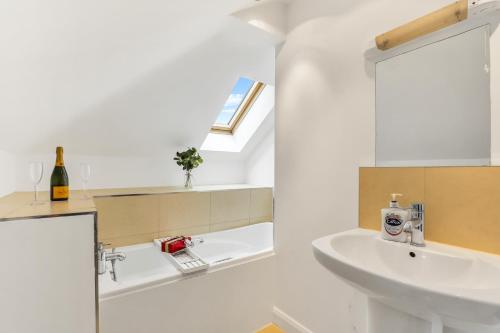uma casa de banho branca com um lavatório e um espelho em Silver Stag Properties, 3 BR Dormer Bungalow em Thringstone