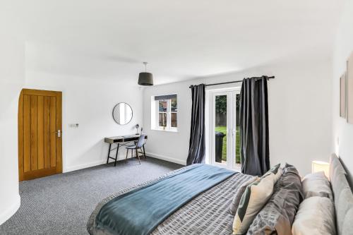 a bedroom with a bed and a desk in it at Silver Stag Properties, 3 BR Dormer Bungalow in Thringstone