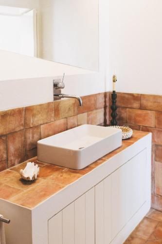 a bathroom with a white sink on a counter at Herdade de Alagães in Mértola