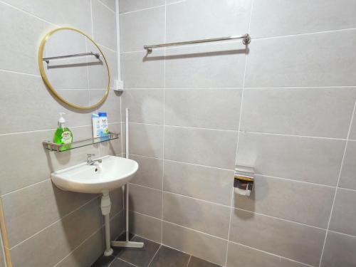 La salle de bains est pourvue d'un lavabo et d'un miroir. dans l'établissement Gem Suites Minimalist 2BR 4beds Entire Apartment, à Kuching