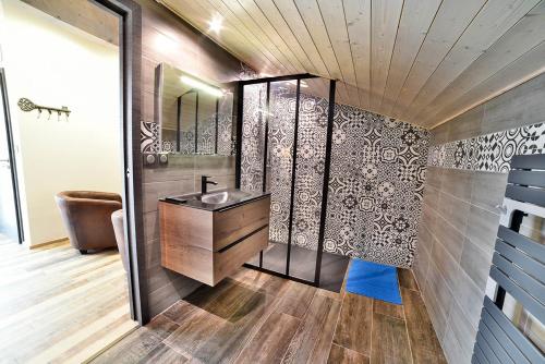 La salle de bains est pourvue d'un lavabo et d'un miroir. dans l'établissement Maison Bord de l'eau, à Ornans