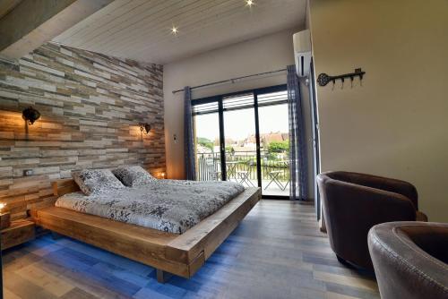 - une chambre avec un lit et un mur en briques dans l'établissement Maison Bord de l'eau, à Ornans