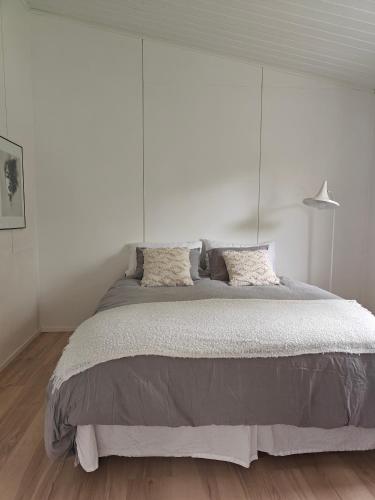 a bedroom with a large bed with a white wall at Sunstar Villa in Rovaniemi