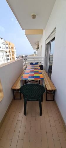 une chambre avec une table et des bancs sur un balcon dans l'établissement Vilamoura-Quarteira Beaches Apt with pool and sea view, à Quarteira