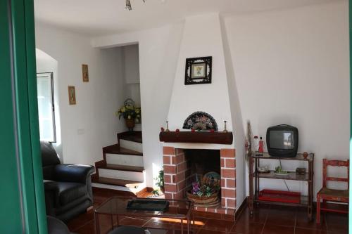a living room with a fireplace and a tv at Casa de Alpalhão in Alpalhão