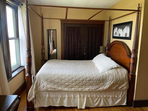 a bedroom with a bed with a wooden frame at Awakenings Inn in Montague