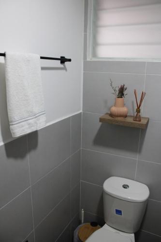 a bathroom with a toilet and a window and a towel at Apartamento en el sur de Cali, Barrio Tequendama in Cali