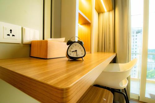 a clock sitting on top of a wooden desk at MESA Thamrin City Apartments at Nagoya with Netflix & Pick Up Service in Nagoya