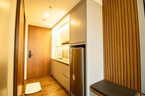a small kitchen with a stainless steel refrigerator at Free Shuttle Thamrin City Apartments at Nagoya with Netflix & Youtube Premium by MESA in Nagoya