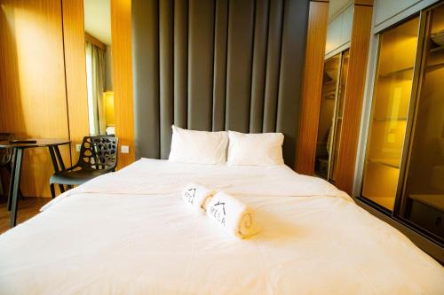 a large white bed with two pillows on it at MESA Thamrin City Apartments at Nagoya with Netflix & Pick Up Service in Nagoya