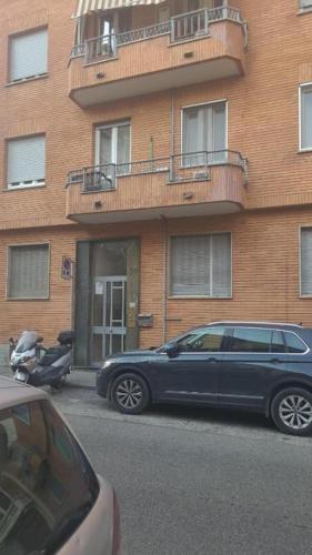 una macchina blu parcheggiata di fronte a un edificio di Apartment Key a Torino