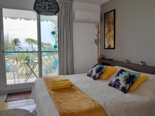 a bedroom with a bed with a view of the ocean at Studio COEUR PASSION VUE MER charme et standing in Saint-François