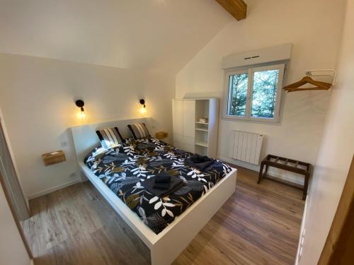 a bedroom with a bed with a black and white comforter at Duplex le Corten, Terrasse et jardin in Gérardmer