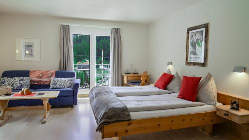 una camera con letto, divano e tavolo di Gletscher-Hotel Morteratsch a Pontresina