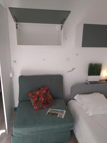 ein Schlafzimmer mit einer grünen Couch neben einem Bett in der Unterkunft hauts des 2 lions -studio in Joue-les-Tours