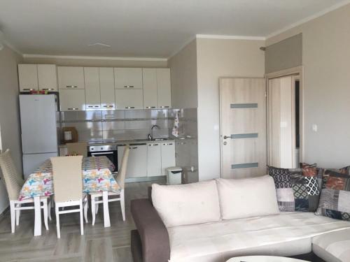 a living room with a couch and a kitchen at Apartments Relax in Utjeha