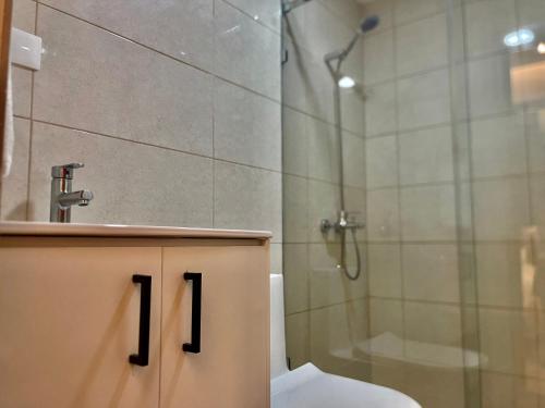 a bathroom with a shower and a toilet and a sink at Downtown Luxury Apt Naco: 2br 2ba in Santo Domingo