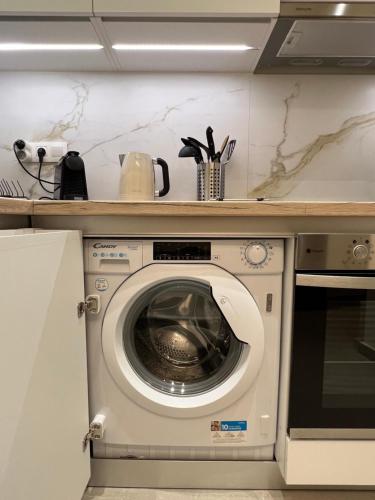 a kitchen with a washing machine under a counter at KK Athens Fine Stay-Steps to Metro-Modern & Cozy Apartments in Athens