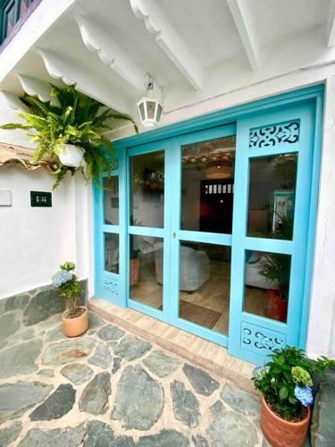 a blue door on a building with potted plants at Clareman in Villa de Leyva