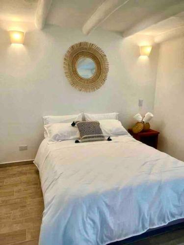 a bedroom with a white bed with a laptop on it at Clareman in Villa de Leyva