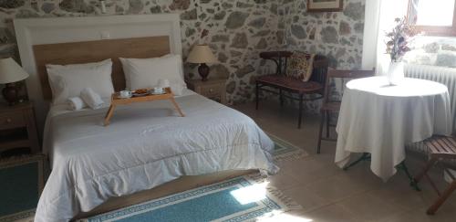 a bedroom with a bed and a table and chairs at Vilaeti Artemis in Agios Konstantinos