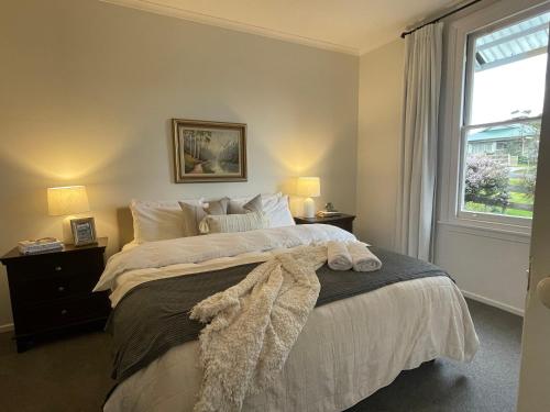 a bedroom with a large bed and a window at Old Maffra Cottage in Maffra