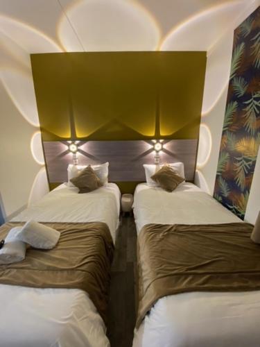 ディジョンにあるFASTHOTEL A Dijonのベッド2台 ホテルルーム 照明付
