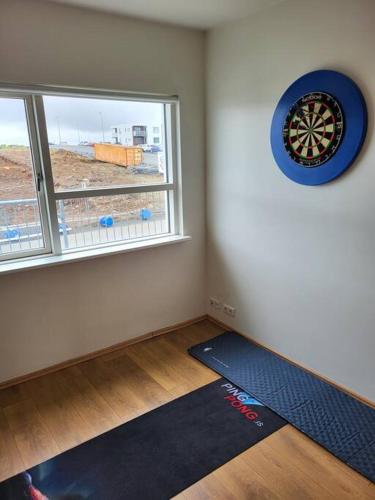 a room with a blue clock and a yoga mat in front of a window at Reynidalur apartments in Njarðvík