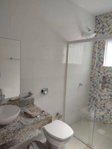 a bathroom with a shower and a toilet and a sink at Pousada Falls Park in Foz do Iguaçu