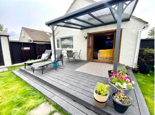 una terraza de madera con macetas en un patio en Ty Gwyn, en Prestatyn