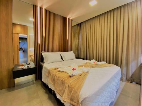 une chambre avec un grand lit recouvert de fleurs dans l'établissement Flat Île de Pipa Premium - By Almare, à Pipa