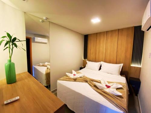 - une chambre avec un lit orné de 2 fleurs blanches dans l'établissement Flat Île de Pipa Premium - By Almare, à Pipa