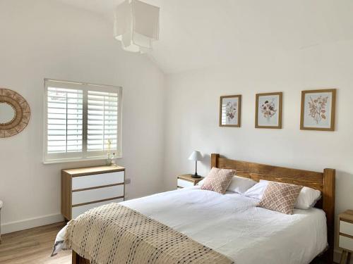 a white bedroom with a bed and a window at Converted Barn at Stonehouse Farm 