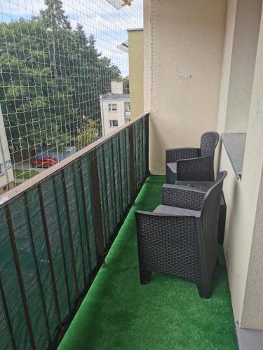 two chairs on a balcony with green grass at Apartament Królowej Jadwigi in Iława