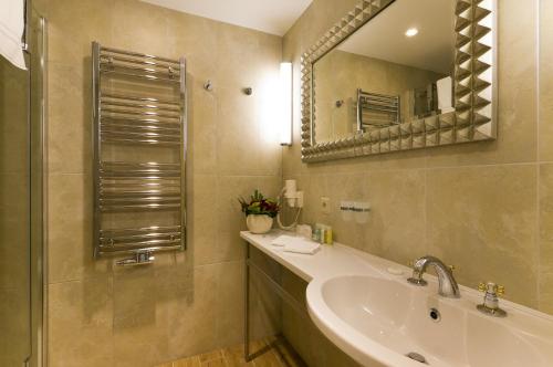a bathroom with a sink and a mirror at Grandhotel Ambassador Národní Dům in Karlovy Vary