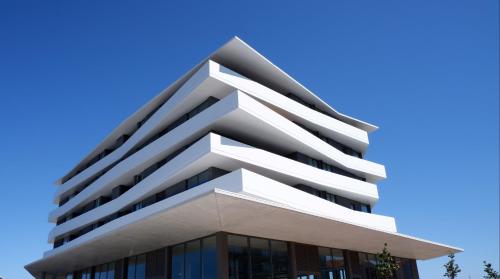 a tall white building with a blue sky in the background at J.M. Stay Aveiro in Aveiro