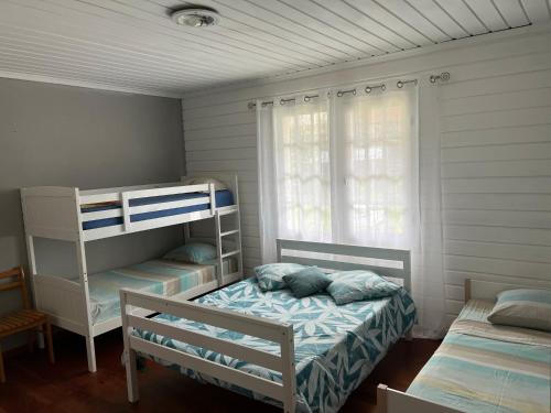 a bedroom with two bunk beds and a window at Le Calbanon cilaos in Cilaos