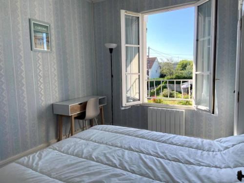 卡布爾的住宿－La Maison Cabourgeaise proche mer，一间卧室设有两张床和窗户。