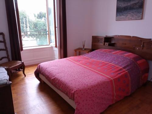 ドゥアルヌネにあるGîte du port Rhuのベッドルーム1室(赤毛布、窓付)