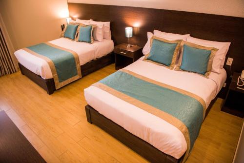 um quarto de hotel com duas camas com almofadas azuis em Hotel Diamond Lima em Lima