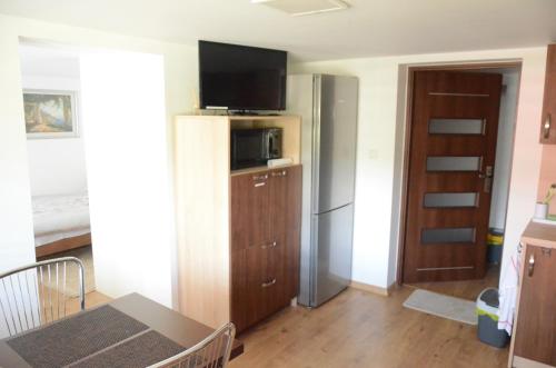 a kitchen with a refrigerator and a table in a room at Pod Rusztem Agroturystyka in Wysowa-Zdrój