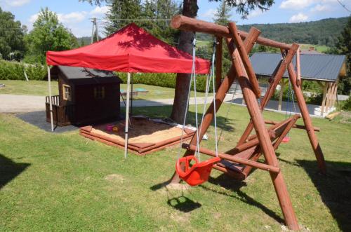 a playground with a red tent and a swing at Pod Rusztem Agroturystyka in Wysowa-Zdrój