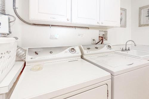 a white laundry room with two sinks and white cabinets at Berni's Ocean View Castle - Home Sweet Homestead in Oceanside