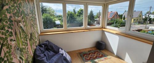 a small room with three windows and a couch at APARTAMENT Cicha Przystań in Gdańsk